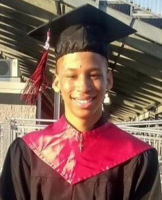A young lad wearing graduation clothes